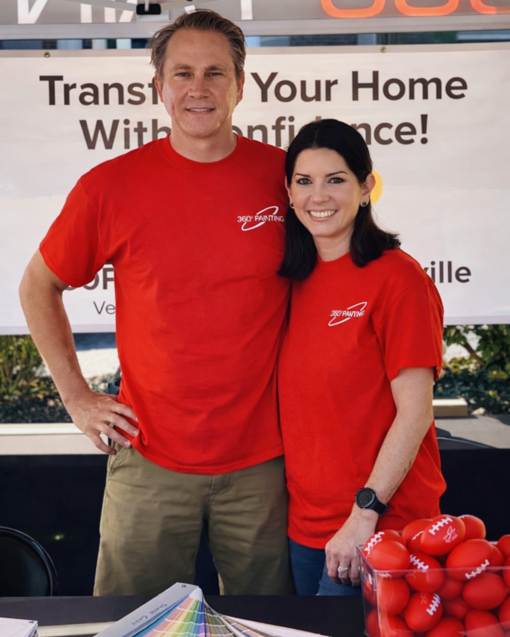 A person and person standing next to a table with red footballs

AI-generated content may be incorrect.